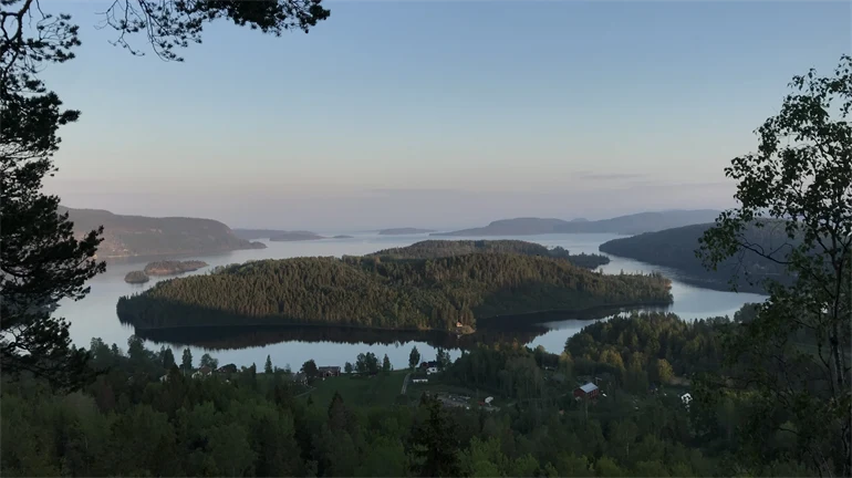 Utsikt över skogsklädda öar i stilla vatten.