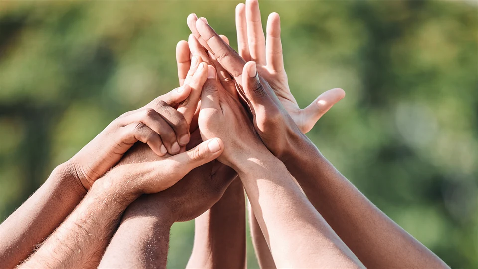Multiple hands coming together in a high five