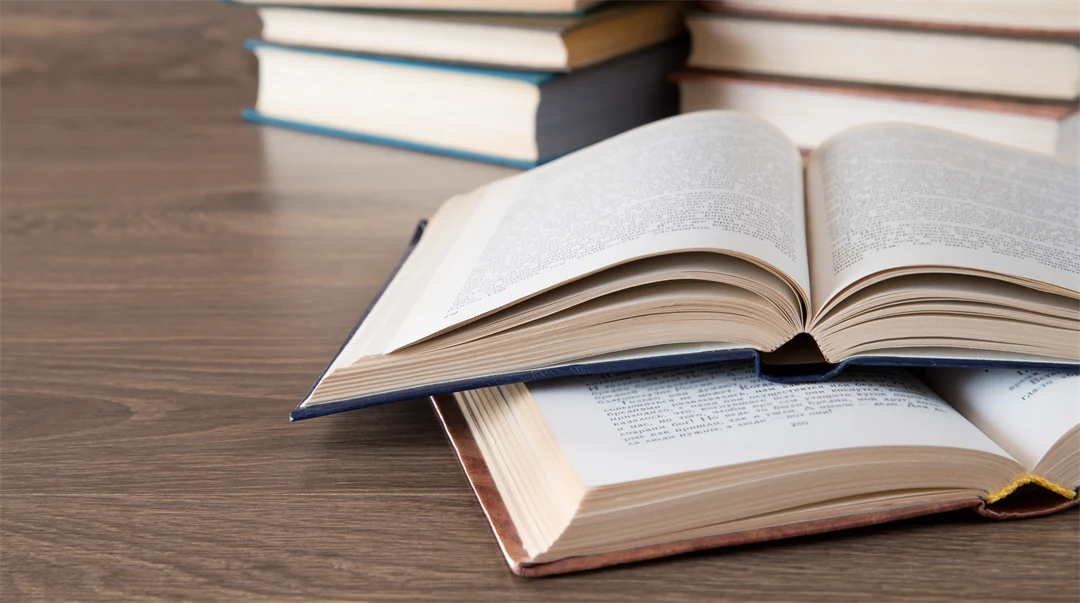 Flera öppna böcker ligger på ett bord