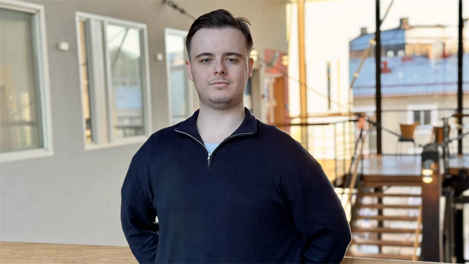 Man with a dark blue sweater and brown hair.