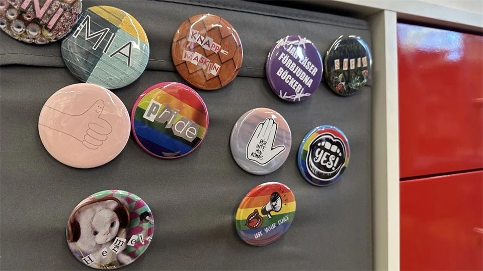 olika knappar med slogan uppsatt på en tygvägg.