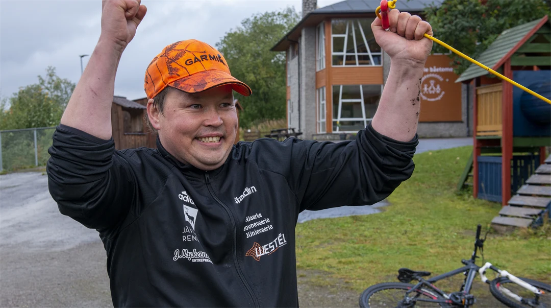 En leende man som gör en vinnargest.