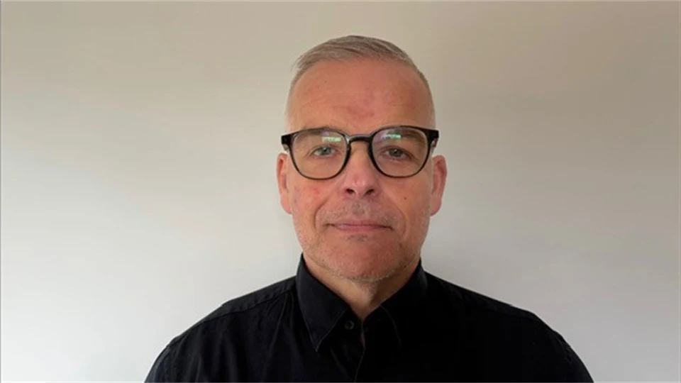 Person som står framför en vit bakgrund