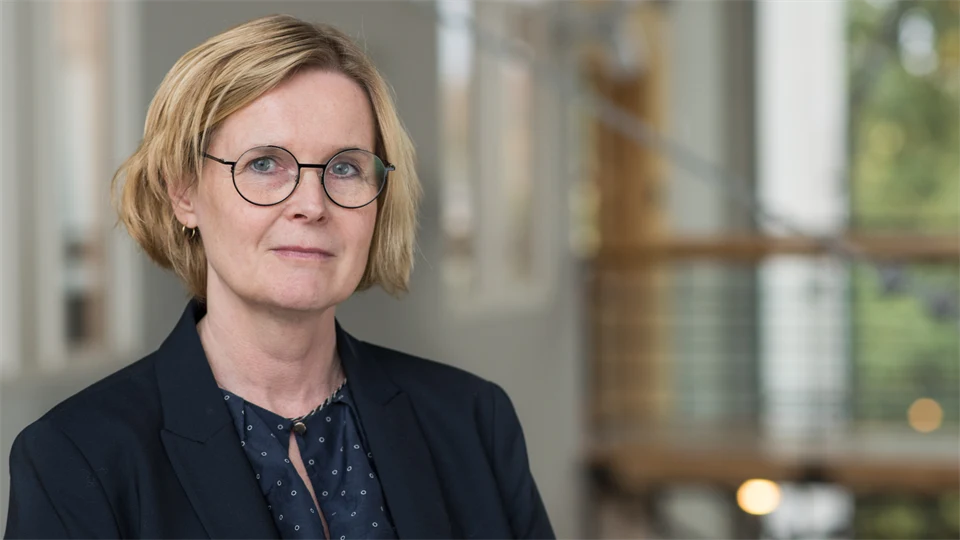Porträttbild på kvinna med ljust hår och glasögon