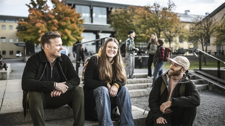 Tre studenter som sitter i en trappa utanför Campus Östersund