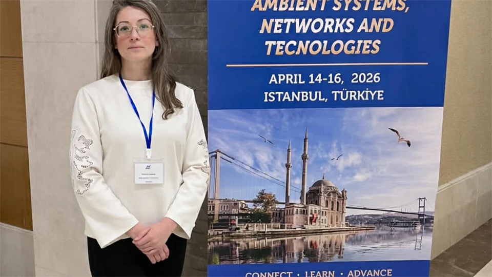 Victoria Kazieva framför en rollup på en konferens