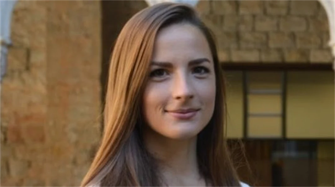 A woman with brown hair smiles at the camera