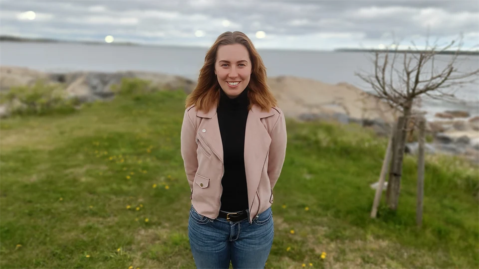 Kvinna med brunt hår och en rosa jacka