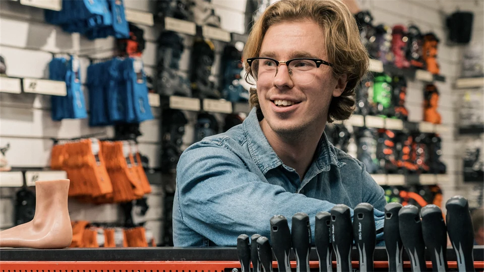 Kille i butiksmiljö med skidartiklar i bakgrunden