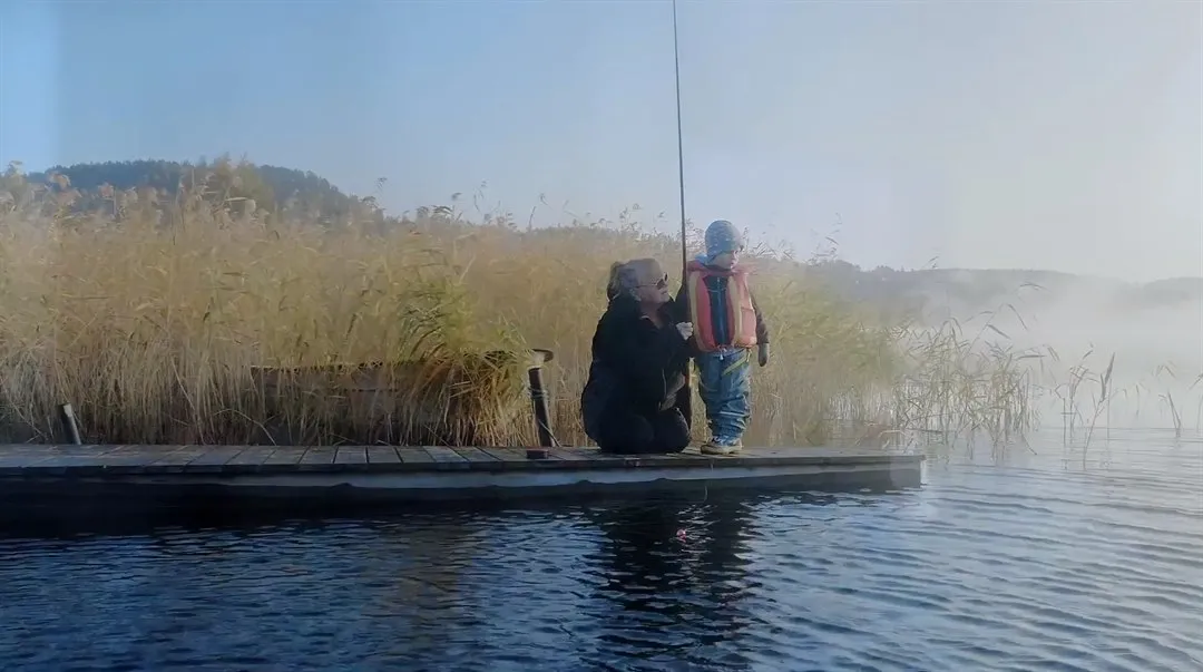 Morförälder och barn på en brygga