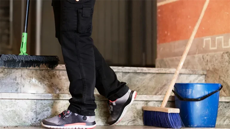 En lokalvårdare som städar en trappa