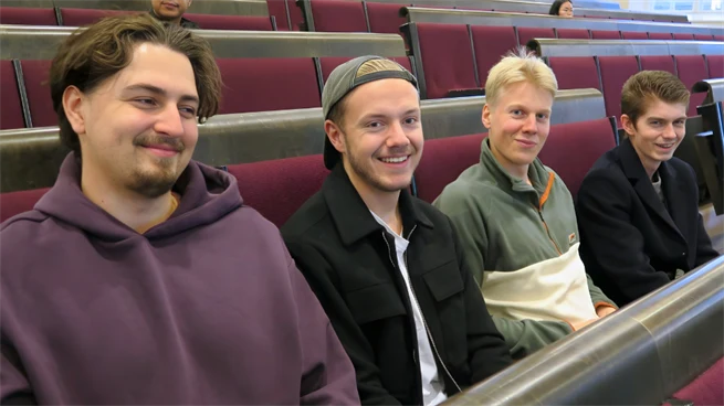 Fyra manliga studenter sitter i bänkarna och väntar in att dagen ska börja