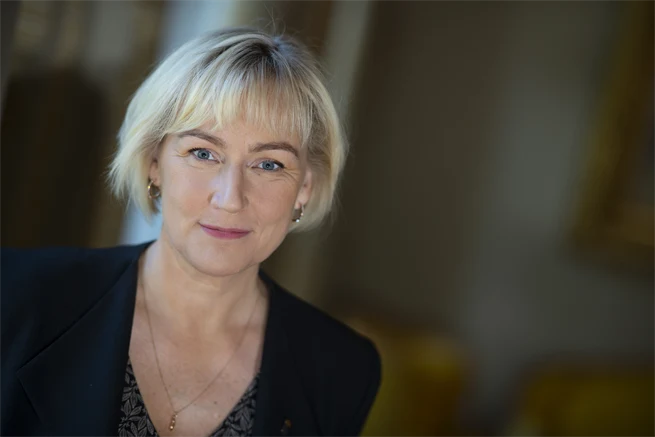 Porträtt av blond kvinna i svart kavaj