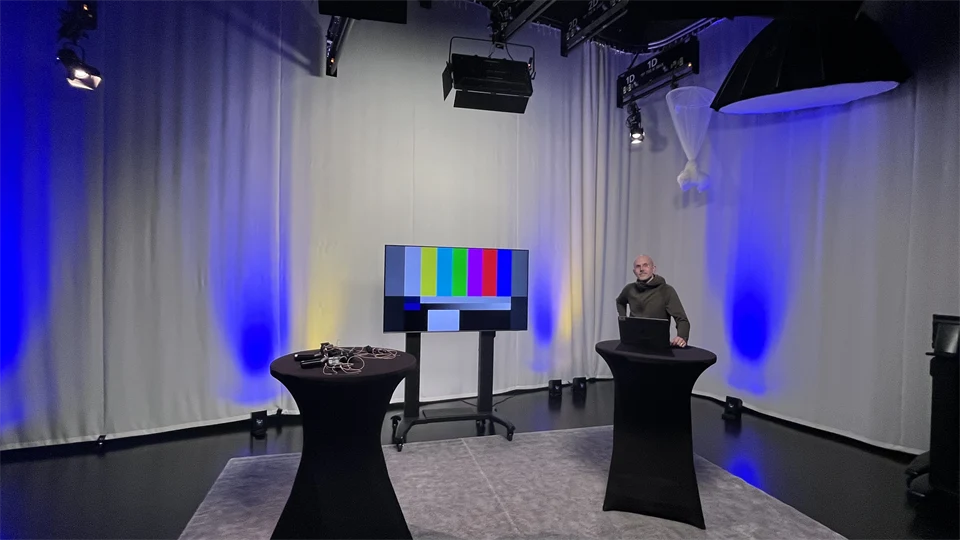 Man står vid ett av två ståbord i en TV-studio
