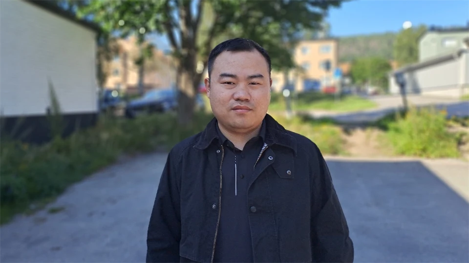 En man med svart jacka utomhus