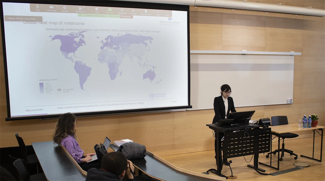 En person håller en presentation, på en stor skärm visas en bild som föreställer en världskarta.