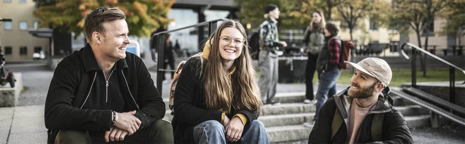 Tre studenter som sitter i en trappa utanför Campus Östersund