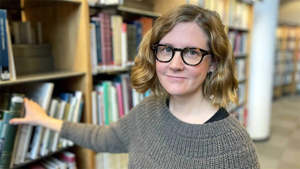 woman standing by a book shelf