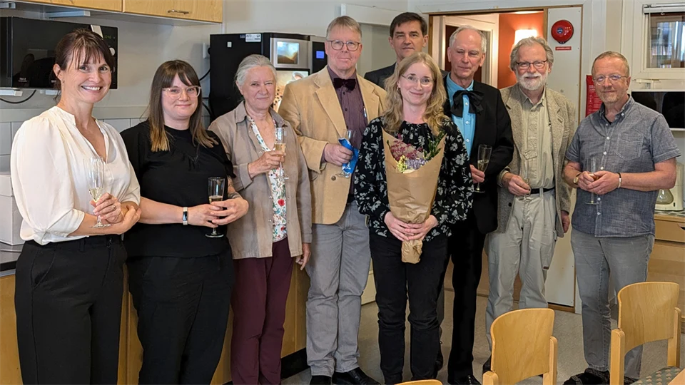 Gruppbild med nio personer som står framför kameran.