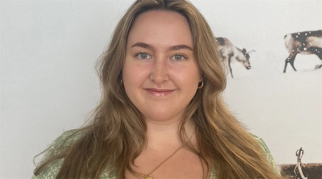 Kvinna med grön klänning mot vik bakgrund