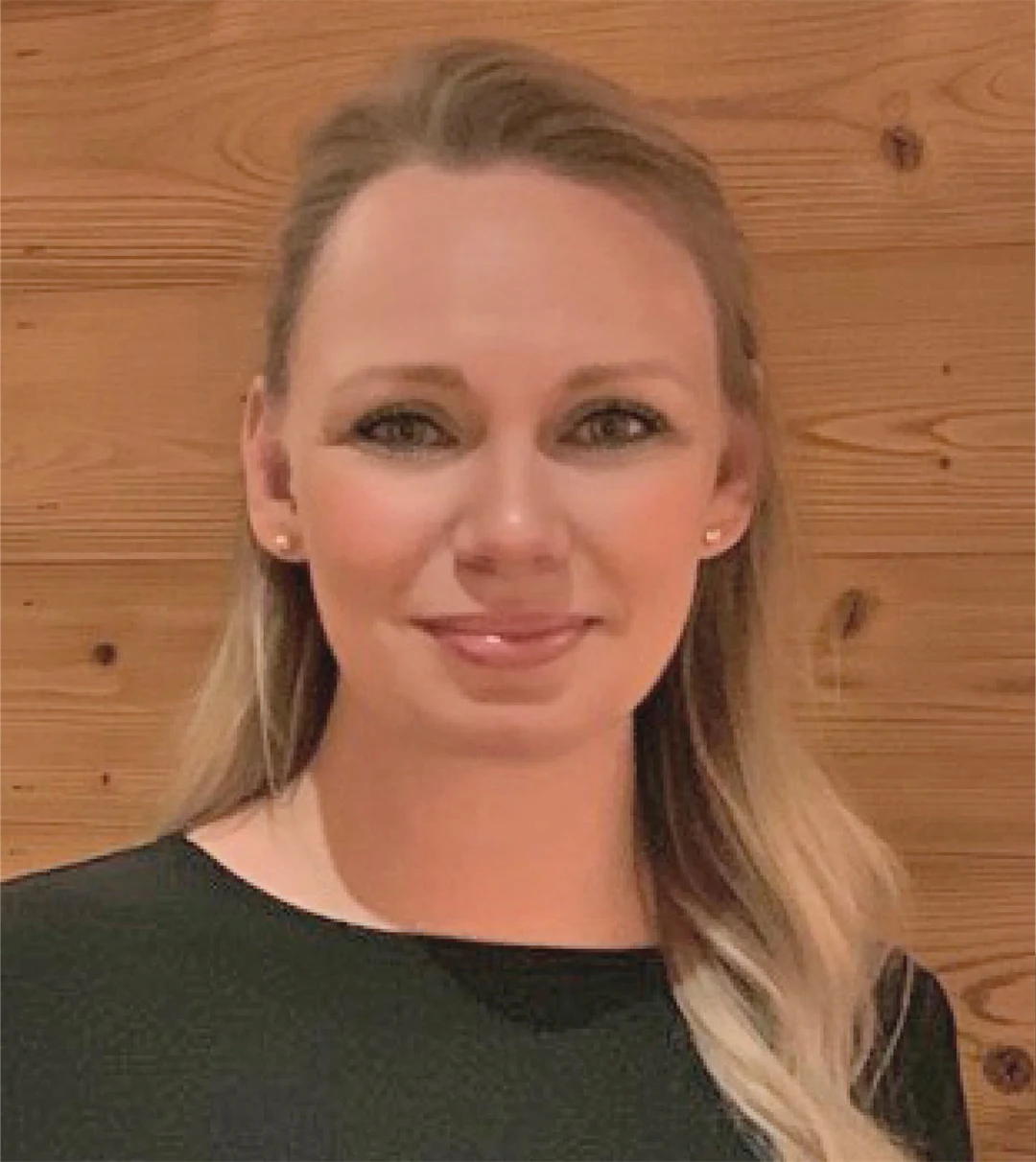 en kvinna ler och tittar in i kameran