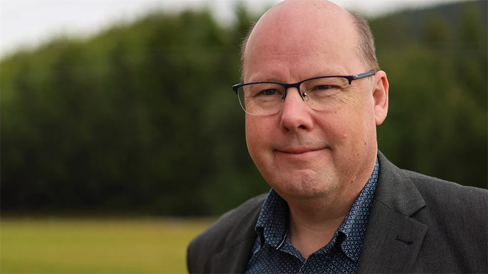 A man without hair and black glasses