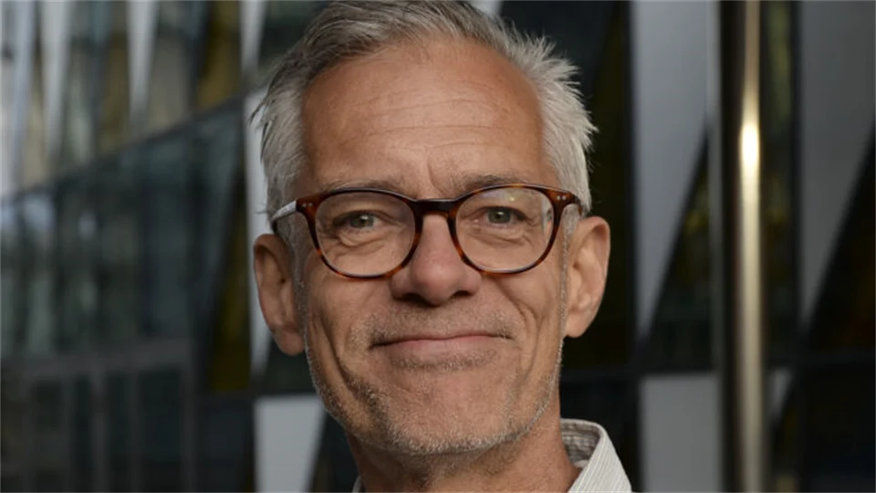 En man med glasögon och en denimskjorta