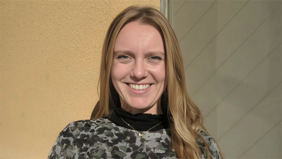 Jana Brehmer ståendes framför en av Mittuniversitetets byggnader på campus i Östersund