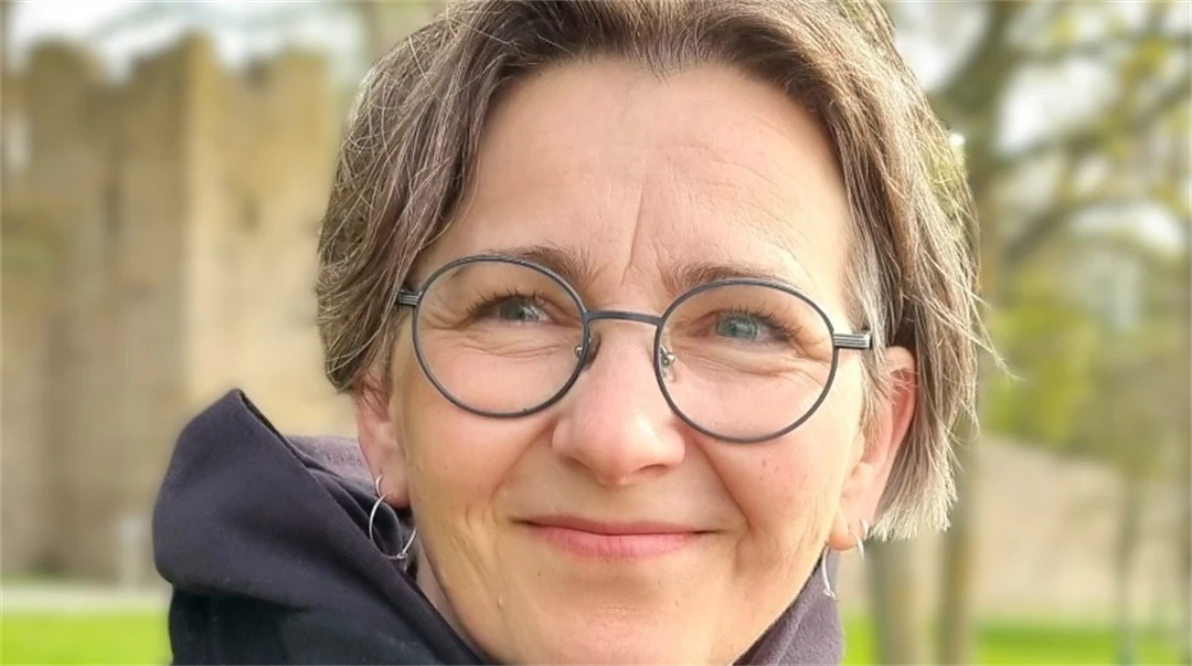 A woman with brown hair and round glasses