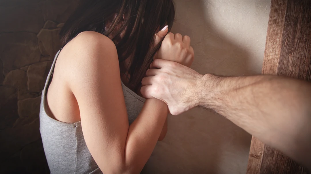 Man greppar tag om kvinnas arm