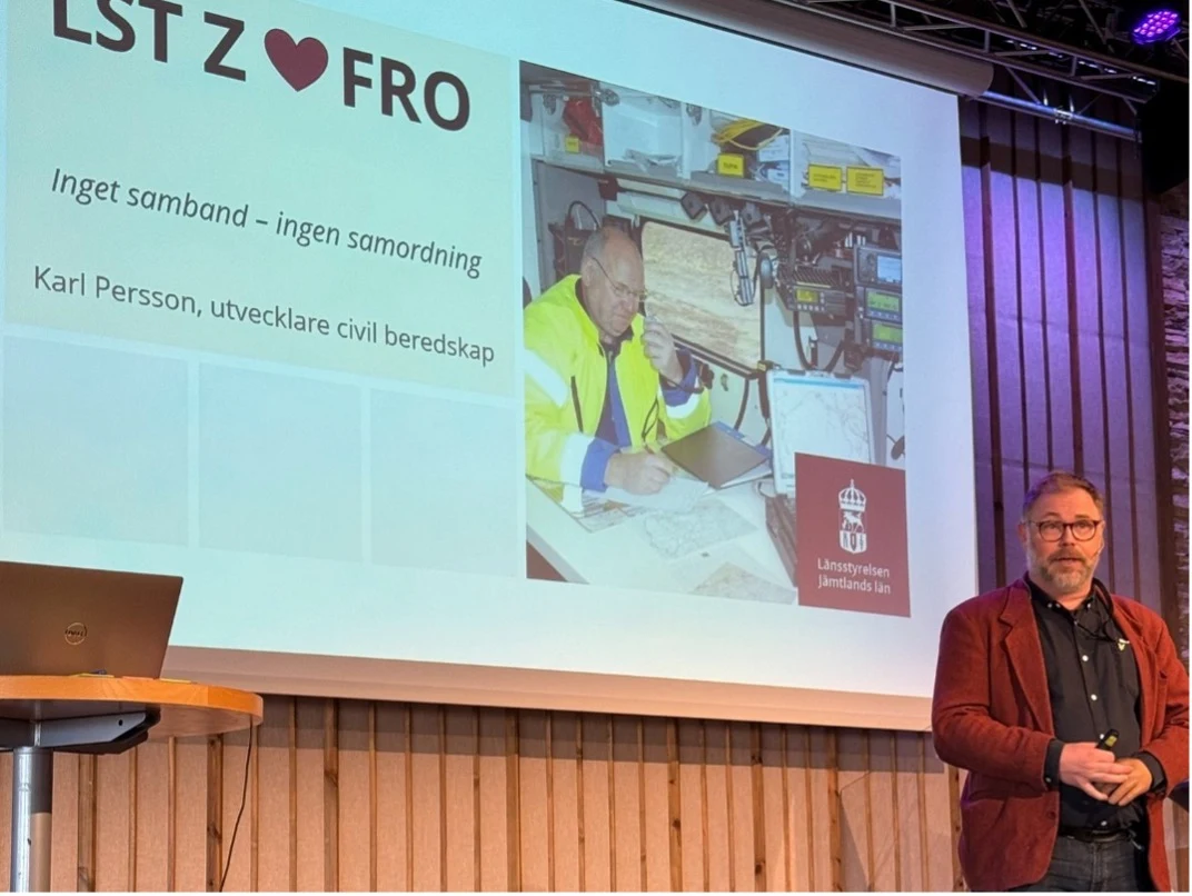 En man som står framför en stor projektorduk och föreläser