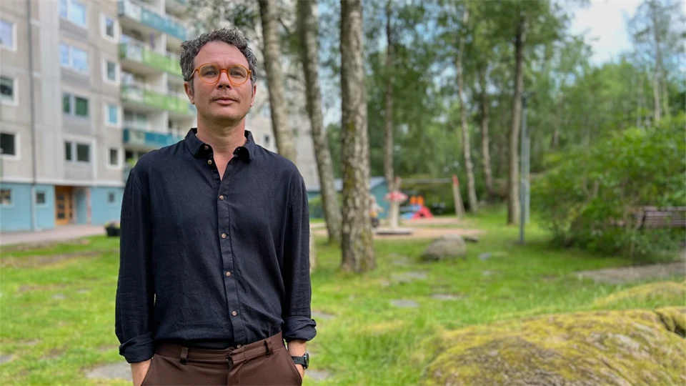 A photo of a man with short hair, blue shirt and glasses