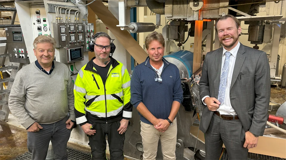  Four men standing together in an industrial building