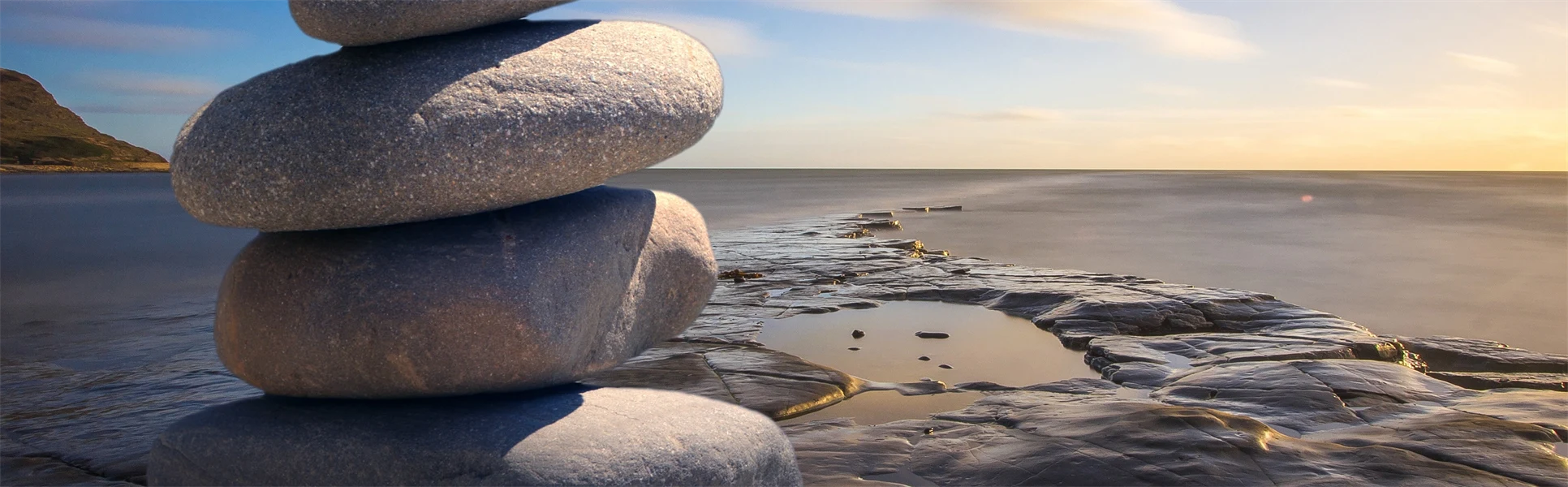Släta stenar staplade på varandra vid stranden. 