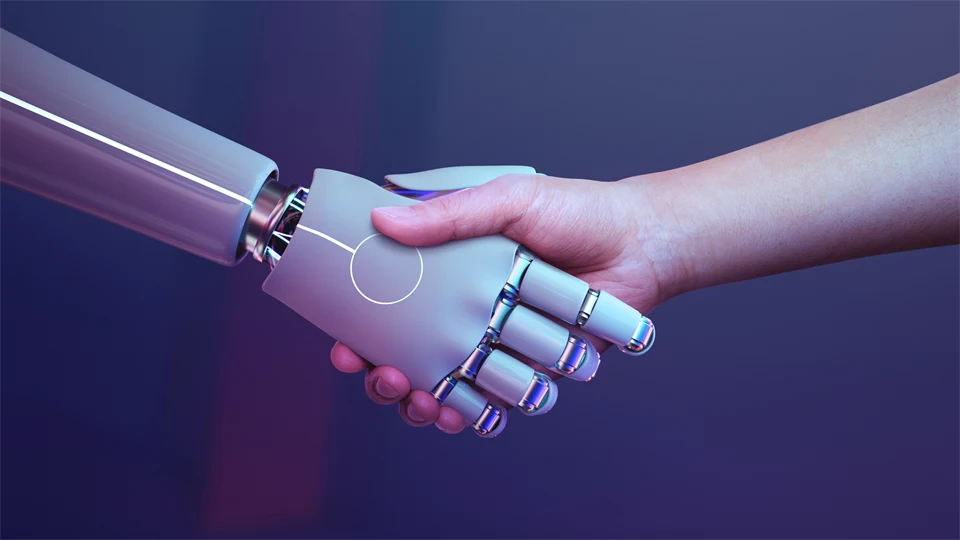 En robothand och en mänsklig hand som hälsar i ett handtag.