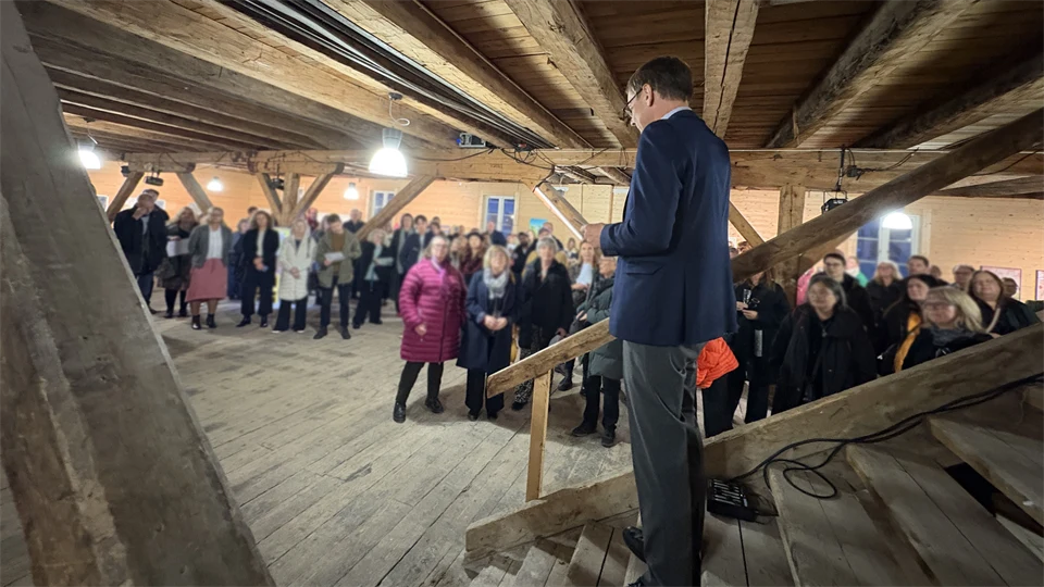 En man står på en trappa, publik i bakgrunden