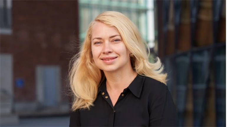 Leende blond kvinna utomhus.