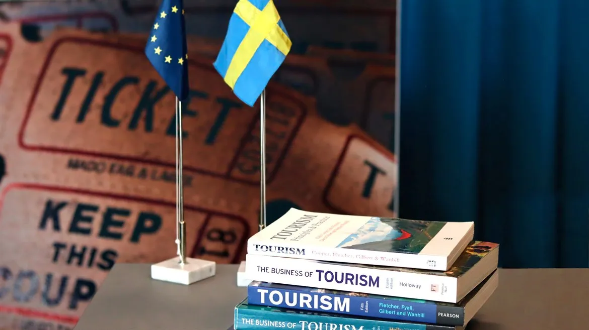 Turismböcker, en svensk flagga och en EU-flagga på ett bord