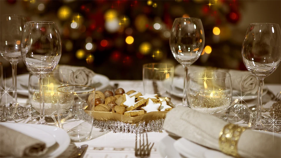 Ett festligt dukat bord med porslin, glas och servetter. 