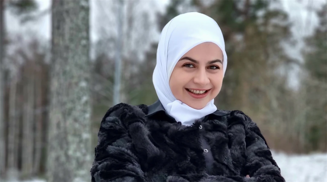 En ung leende kvinna i en skog 