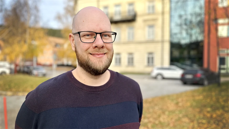 Man med glasögon står utomhus.