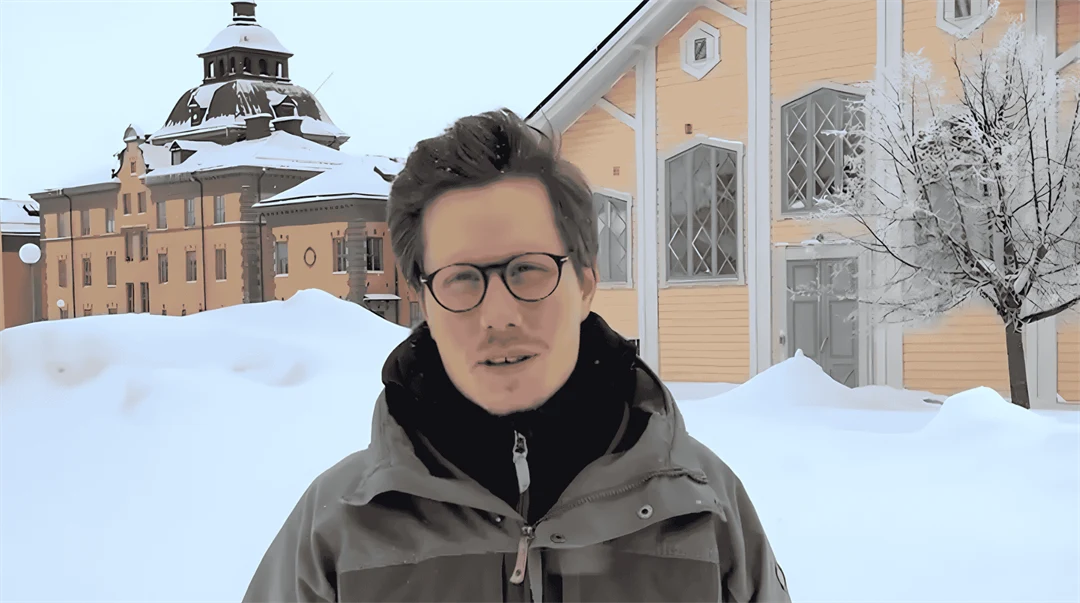 Studenten Simon står ute på gården på Mittuniversitetets campus i Östersund. Det är vinter och mycket snö.