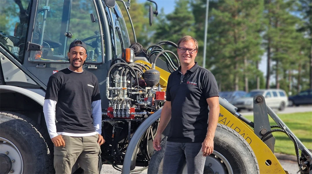 Två män framför en traktor