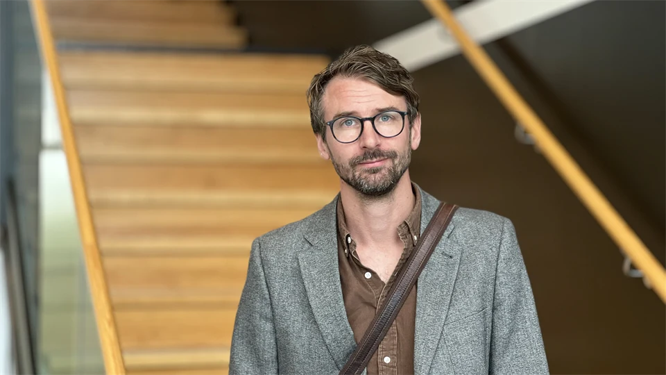 En man med glasögon ståendes i en trappa