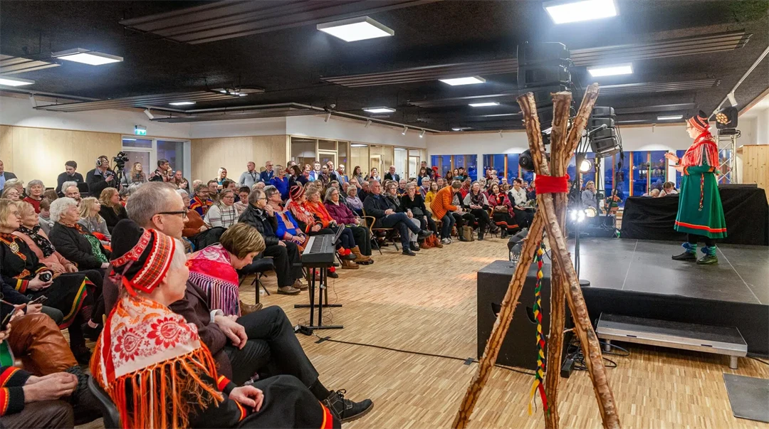 En publik framför en person på en scen