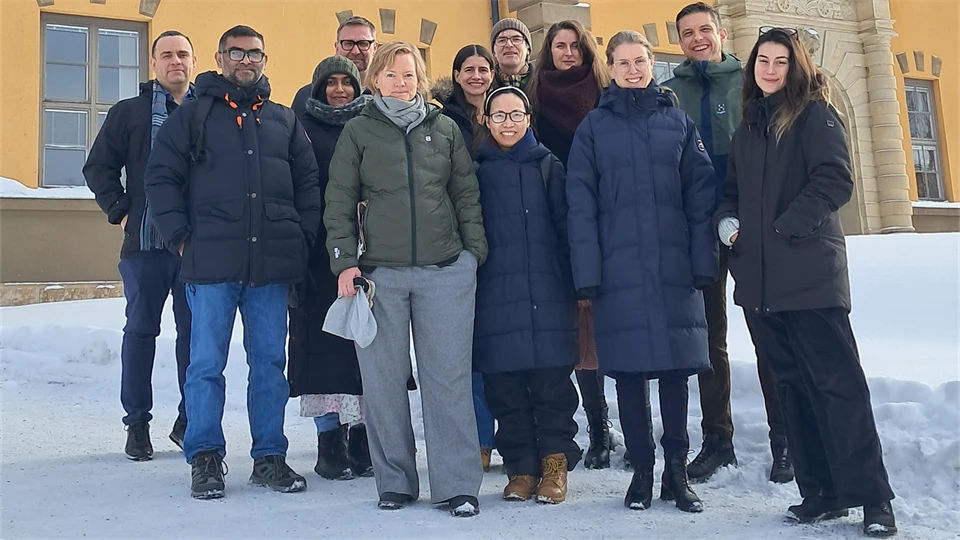 Grupp människor framför gul stenfasad