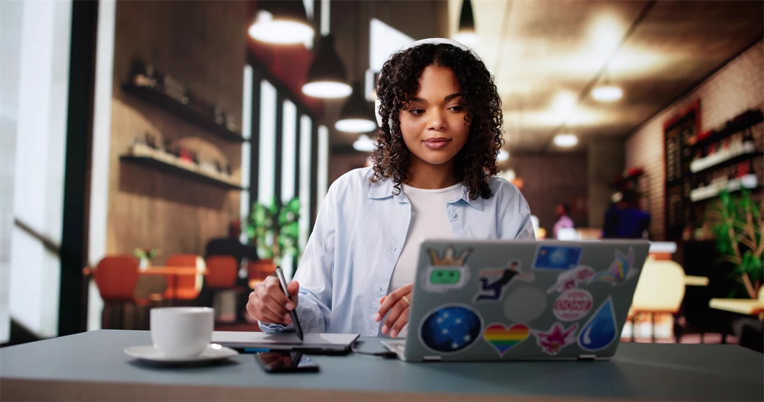 A young dark-haired woman is sitting in front of a laptop.